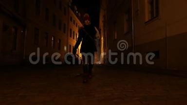 这位年轻女子正在欧洲老城黑暗的<strong>街道</strong>上<strong>行走</strong>。里加，拉脱维亚
